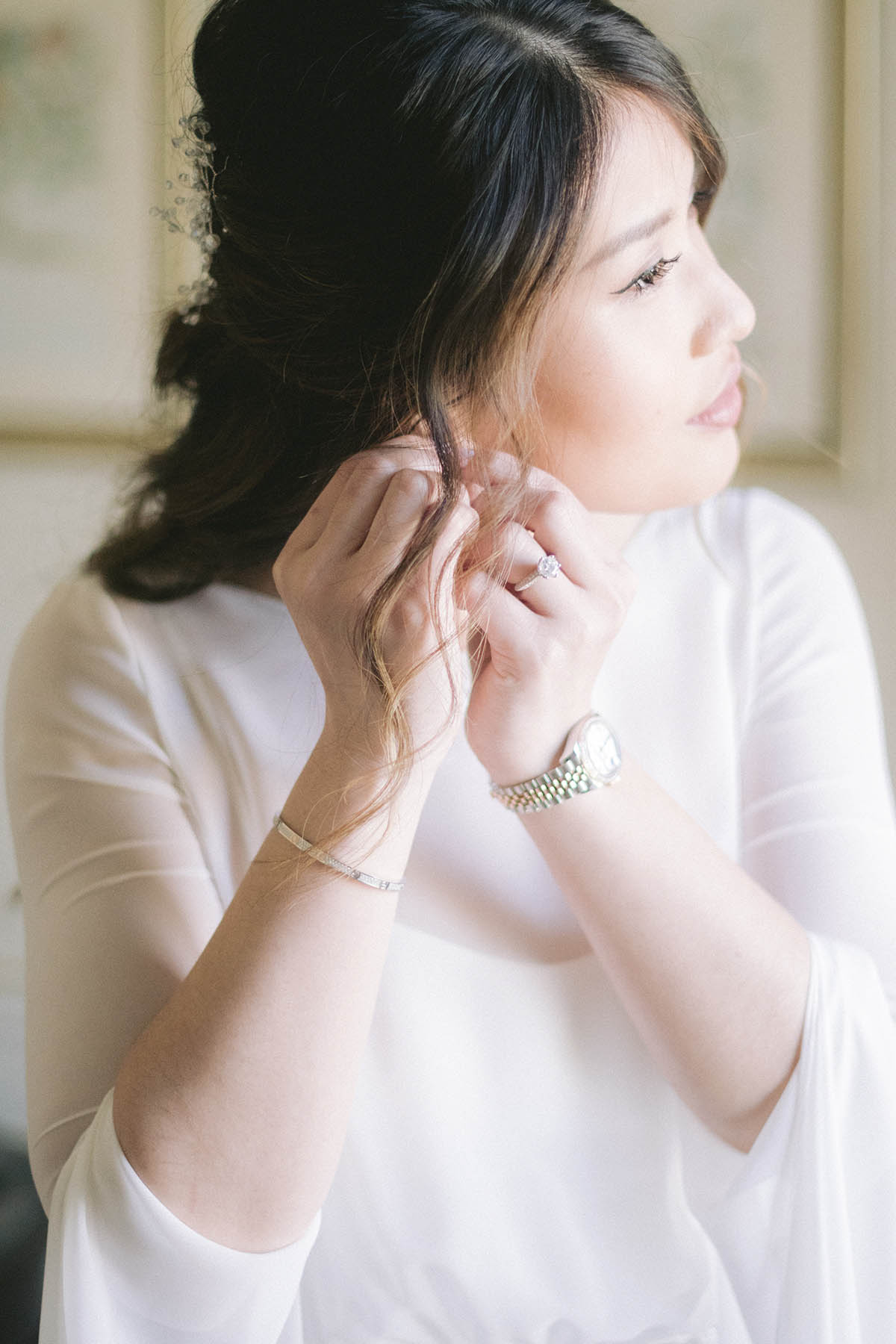 une mariée attache ses boucles d'oreilles